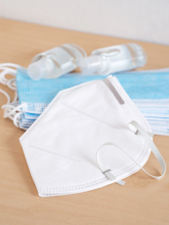 Medical face mask and hand sanitizer alcohol gel on beige background. Concept of coronavirus outbreak and pollution. New normal.の写真素材