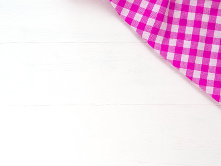 Top view, close-up of pink and white checkered fabric or napkin on white table background. Concept kitchen utensils and tableware. Top view, flat lay with copy space.の写真素材
