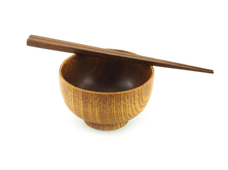 Empty wooden bowl and chopsticks isolated on a white background.  Used  serving for home or restaurant, food design. Kitchen accessory.の写真素材