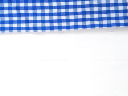 Top view, close-up of blue and white checkered fabric or napkin on white table background. Concept kitchen utensils and tableware. Top view, flat lay with copy space.の写真素材