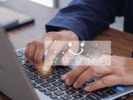 Customers using laptop to send satisfaction surveys with smiley face icon of 5 stars. Customer service evaluation, Experiences, Feedback, and Satisfaction survey concept.の写真素材