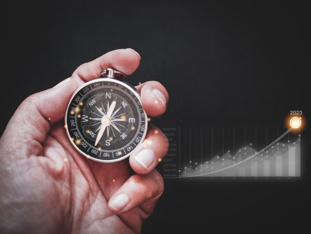 Businessman holding compass inside with globe icon and a graph showing business growth, goal plan 2023の写真素材