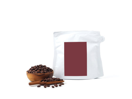 Foil plastic white paper bag packaging with zipper and brown label, wooden bowl, scoop of seed isolated on a white background. Package mock-up for coffee or dry seeds product.の写真素材