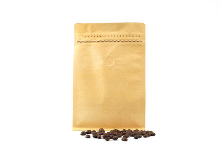 Brown craft paper bag with vacuum-sealed, zipper and pile of seeds for packaging roasted coffee beans template isolated on a white background. Package mock-up for coffee or dry seeds product.の写真素材