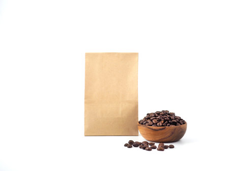 Brown craft paper bag packaging and wooden bowl for roasted coffee beans template isolated on a white background. Package mock-up for coffee or dry seeds product.の写真素材