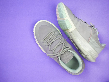 New Grey-light green sneakers isolated on purple background. Unisex sports footwear, fashion style pair of casual sports shoes, Mock-up for sneaker design, logo, a product of sport.の写真素材