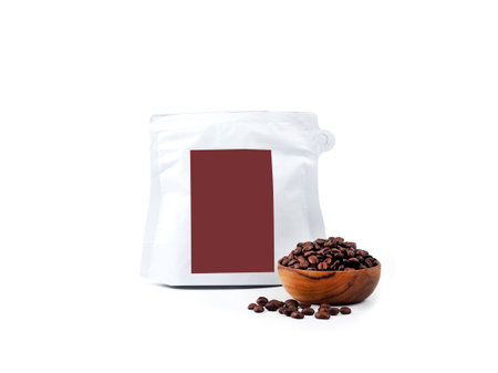 Foil plastic white paper bag packaging with zipper and brown label, wooden bowl of seed isolated on a white background. Package mock-up for coffee or dry seeds product.の写真素材