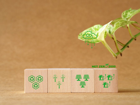 Goals to reduce global warming by using renewable energy alternatives that are environmentally friendly. The target 2050. Net zero and carbon neutral concept. Green energy symbols on wooden cube.の写真素材