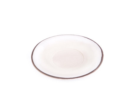 front view, empty beige round ceramic plate with brown rim isolated on a white background. Use for home or restaurant, food design. Kitchen accessory.の写真素材