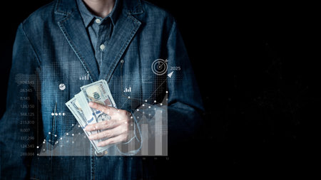 Businessman holding a 100 dollar banknotes and icon a chart showing business growth goals for 2025. Business planning, strategy, budget management and investment. Business technology background.の写真素材