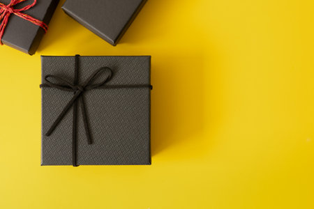 Concept for happy birthday, thank you, congratulations, anniversary, Valentine's day. Top view, flat lay of black gift box tied with black rope on black paper background.の写真素材