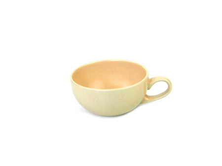 Empty beige mug of coffee or tea isolated on a white background. Use for home or restaurant, food design. Concept kitchen utensils and tableware. Side view.の写真素材