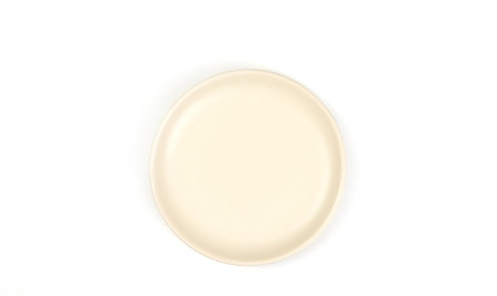 Top view of beige ceramic circle plate isolated on a white background. mockup and template for design, and banner. Use for home or restaurant.の写真素材