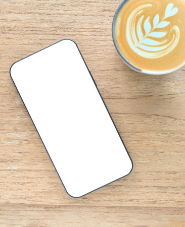 Concept online shopping, blog, logo, product, and social media. Top view, flat lay a modern smartphone with a blank white screen and coffee cup over wooden background. Technology, lifestyle.の写真素材