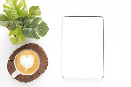 Concept online shopping, blog, logo, product, and social media. Top view of a digital tablet with a blank white screen and coffee cup over a white background. Mockup and template for business.の写真素材