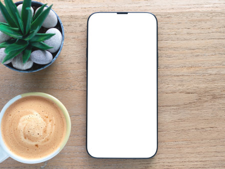 A minimalist flat-lay composition featuring a modern smartphone with a blank white screen over a wooden background. Concept online shopping, blog, logo, product, and social media.の写真素材