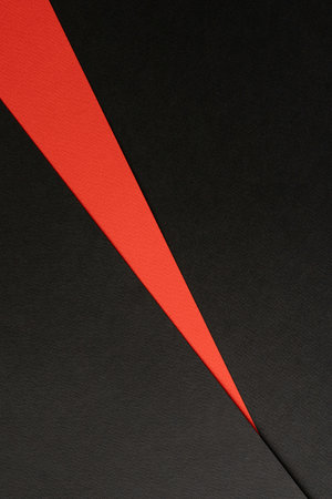 Two-tone color black and red colored paper background. Concept for image, text, and design. Geometric paper backdrop. Abstract paper texture or background.の写真素材