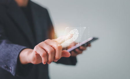 Businessman touching a virtual screen for fingerprint scanning. Biometric authentication concept symbolizes cybersecurity, identity verification, and secure access control with futuristic technology.の写真素材
