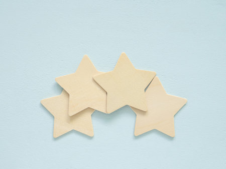 Simple wooden 4 stars on light blue wood. Symbol of rating and quality.  positive feedback, and gentle, calm concepts.の写真素材