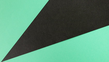 Abstract paper texture or background. Two-tone color green and black colored paper background. Concept for image, text, and design. Geometric paper backdrop.の写真素材