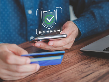 Hand-holding smartphone and credit card in the office. Concept for online payment, shopping online, and internet mobile banking.の写真素材