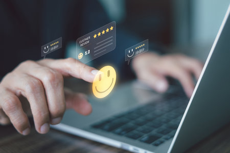 A person is using a laptop and interacting with a digital overlay of a five-star customer review icon, Concept of positive feedback and service excellence. High quality product or services.の写真素材
