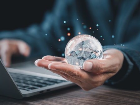 Businessman holding glass blobe with icon global network connections in the office. Big data analytics and business intelligence concept. World map point and line composition in clear glass ball.の写真素材