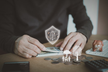 A person protects money with a digital security shield, the importance of wealth protection and family planning. life insurance, financial stability, asset management, and future planning services.の写真素材