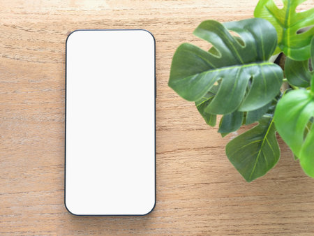 Mockup, template A minimalist flat-lay composition featuring a modern smartphone with a blank white screen over wooden background. Concept online shopping, blog, logo, product, and social media.の写真素材