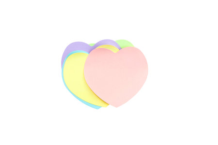 Top view, flat lay with copy space of a charming stack of pastel heart-shaped sticky notes isolated on white background, offering ample copy space for love notes, reminders, or heartfelt messages.の写真素材