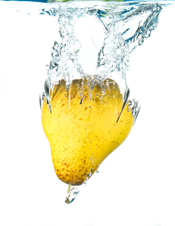fresh pear falling in waterの写真素材