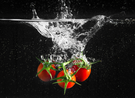 fresh tomatoes falling in pure waterの写真素材