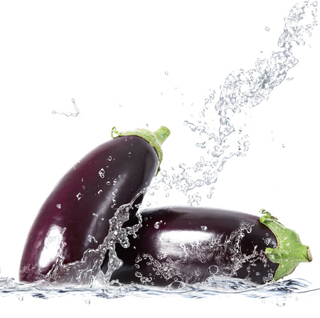 fresh aubergine falling in pure waterの写真素材
