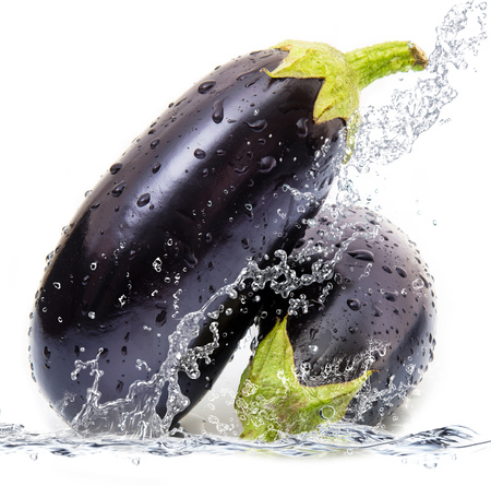fresh aubergine falling in pure waterの写真素材