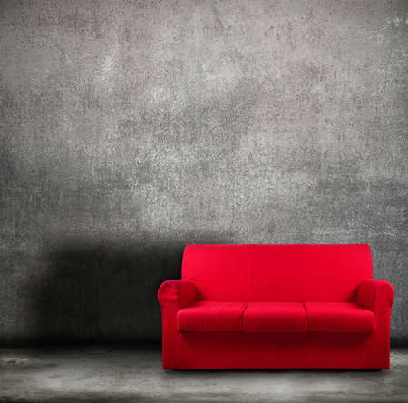 old red sofa on grunge backgroundの写真素材