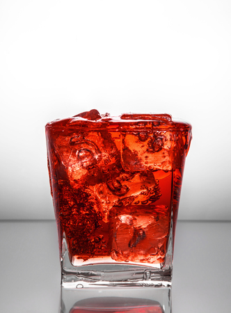 a glass with ice and liquid splashの写真素材