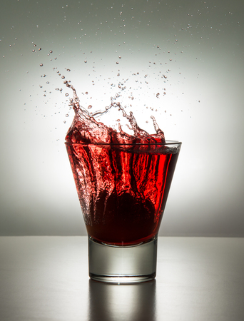 a glass with ice and liquid splashの写真素材