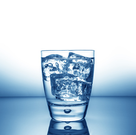 a glass with ice and liquid splashの写真素材