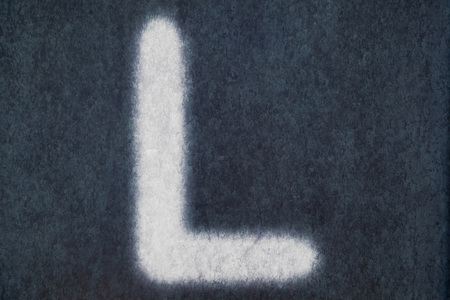 L isolated chalk letter on blackboard background