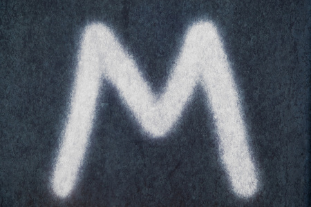 M isolated chalk letter on blackboard backgroundの写真素材
