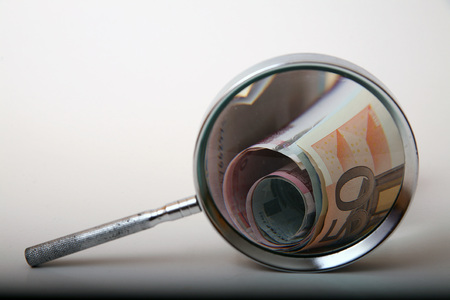 Money under magnifying glass on white backgroundの写真素材