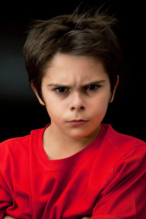 angry young boy on dark background angry young boy on dark background