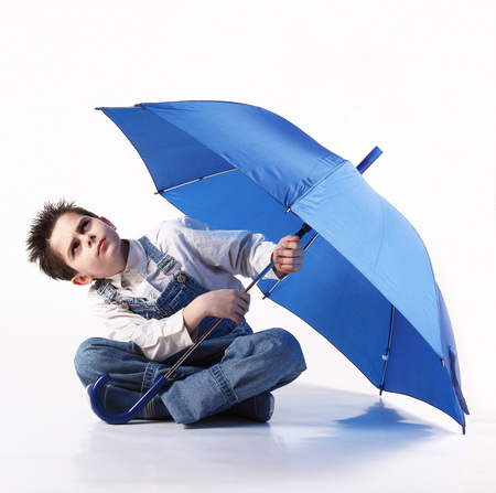 Little boy with an open umbrella looking upの写真素材