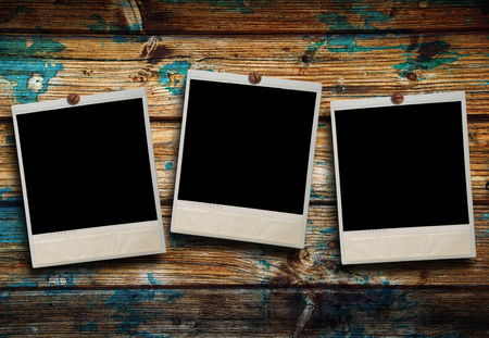 three Old Polaroid hanging on wooden backgroundの写真素材