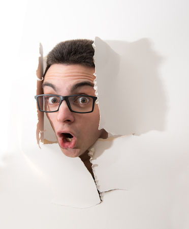 a Boy with head in a torn white cardboardの写真素材