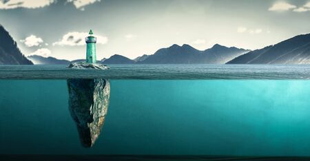 an island with lighthouse in a wild seaの写真素材