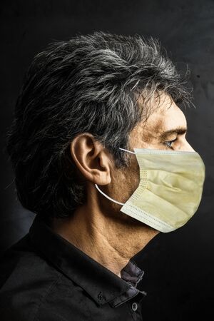 Portrait of Caucasian man in profile with surgical maskの写真素材