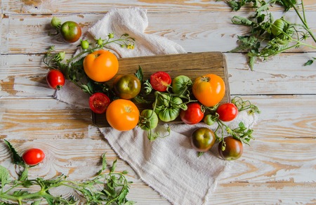 Composition of colorful ripe summer tomatoes. Flatlay. White vintage wooden backgroundの写真素材