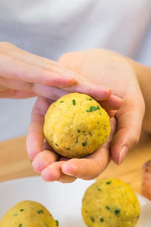 Forming falafel balls. Hands making round falafel pieces out of minced chick peas