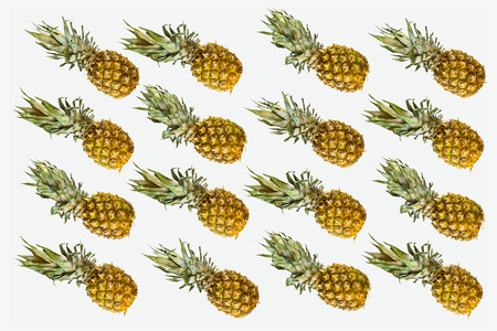 Isolated pineapples pattern on white background. Summer concept of fresh ripe whole pineapples shot...